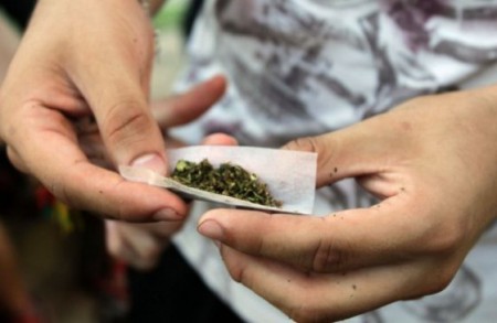 Jóven haciendo su propio cigarillo de marihuana.